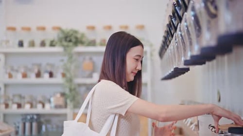 Young Woman Fills Jar in Zero Waste Store