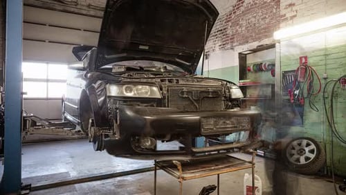 Auto Mechanic At Work Repairing Car On A Car Lift Alone In Automotive Service Garage. timelapse