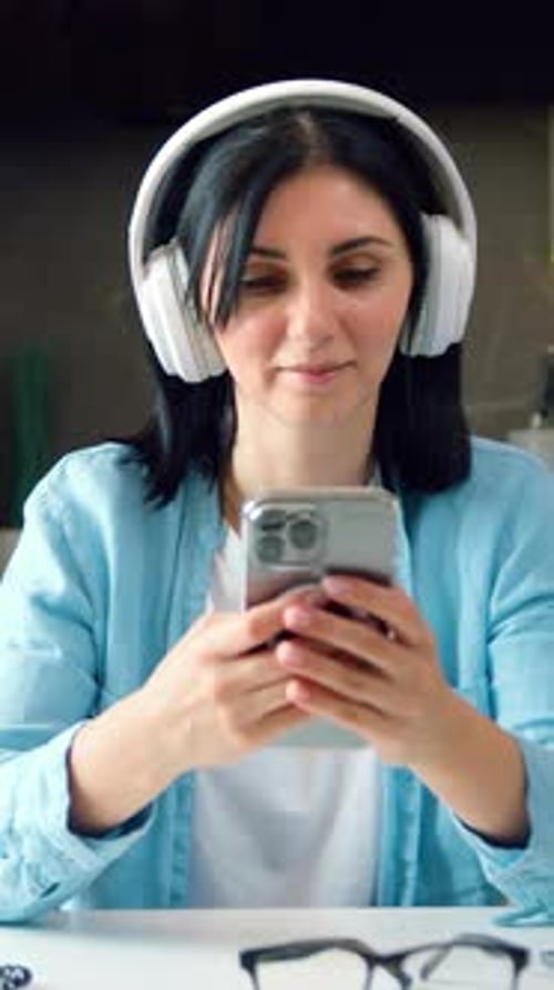Brunette Woman with Headphones Using Smartphone Indoors