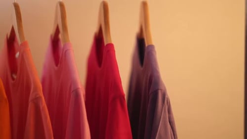 Colorful T-Shirts Hanging on Wooden Hangers