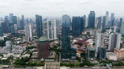 Aerial backward over Jakarta skyscrapers at daytime, Indonesia