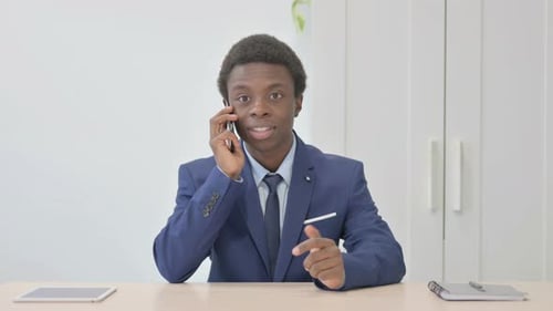 Young African Businessman Talking on Phone in Office