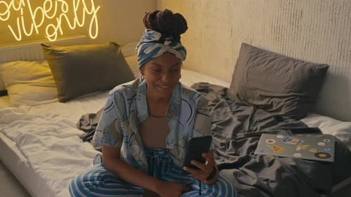 Young Woman Video Calling on Phone in Bedroom