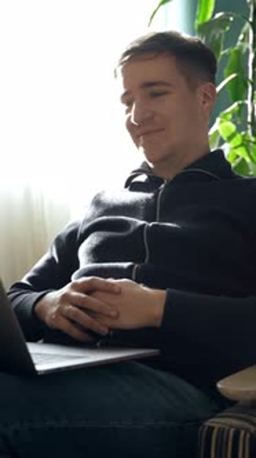 Young Adult Using Laptop Computer at Home