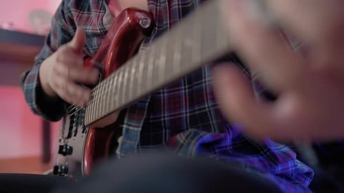 Close Up Shot of Cheerful Woman Teenager Playing Guitar While Sitting