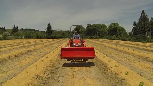 Aerial of Man Driving Tractor on Farm