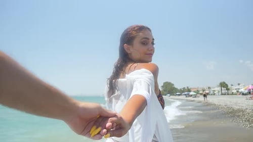 Suivez-moi, point de vue d'une belle femme en blanc se tenant la main et vous conduisant dans une région tropicale
