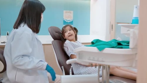A little cute girl having teeth examined by dentist in dental clinic