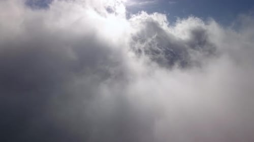 Drone Fly Through Cumulus Clouds and Sunlit Sky