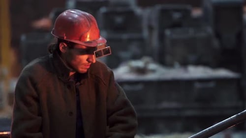 Man Wearing Hardhat Holding Metal Rod Indoors