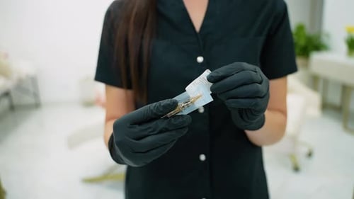 Person Opens Needle Package in Medical Setting