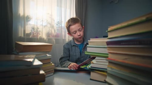 Boy Reading a Book at a Table