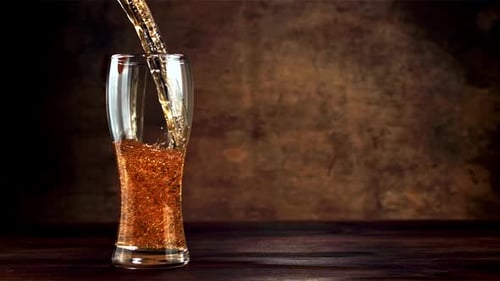 Beer Pouring into Glass on a Wooden Table