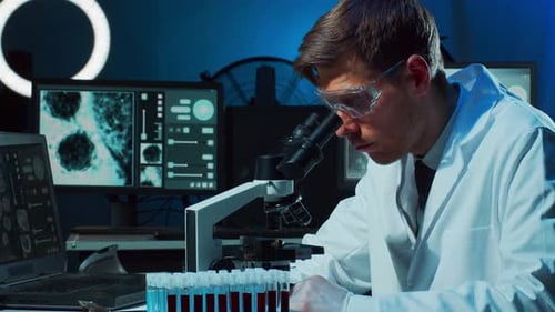 Scientist Researching Under Microscope in Laboratory Setting