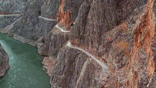 Jeep Driving on Winding Cliffside Road Carved Into Rocky Walls in Kemaliye Canyon