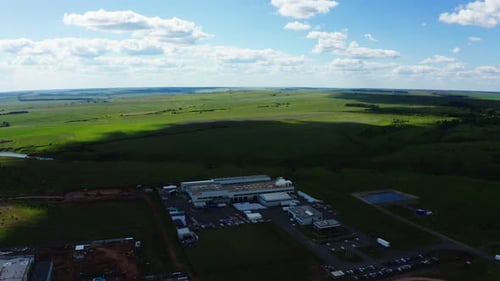 Area of Production Complex Against Green Field Aerial View