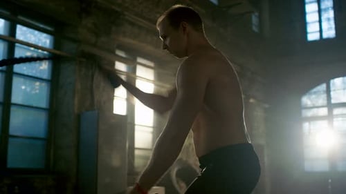 Strong Muscular Shirtless Sportsman Works out Hard with Battle Ropes as Part of His Cross Fitness T