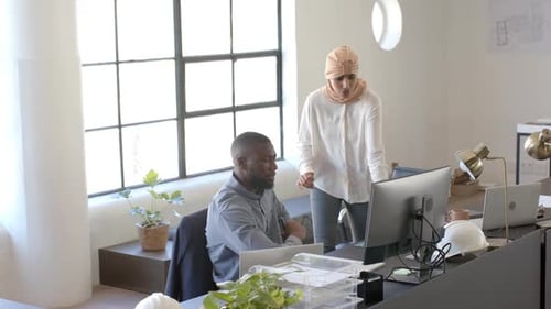 Colaborando no projeto, colegas discutindo o trabalho na mesa do escritório com o computador