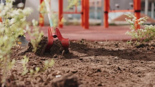 Loosening Soil with Garden Hoe During Landscaping Work Close Up