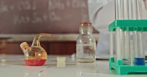 Visionnez un plan panoramique sur un banc dans un laboratoire de chimie, des tubes à essai dans un rack et des produits chimiques dans