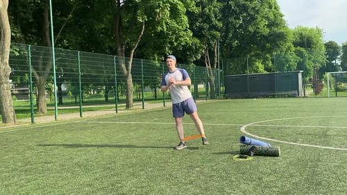 A Male Athlete Works Out on a Sports Field in the Morning