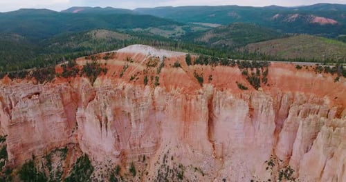 Stunning huge rock of coral color in Bryce National Park. Mountains overgrown with pine forest