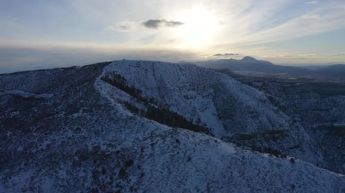 Beautiful view of a snow covered mountain with a razor sharp summit, surrounded by lush vegetation,