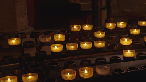 Concept of memorial day, religion, prayer, God. A lot of burning candles in temple. Flame burning