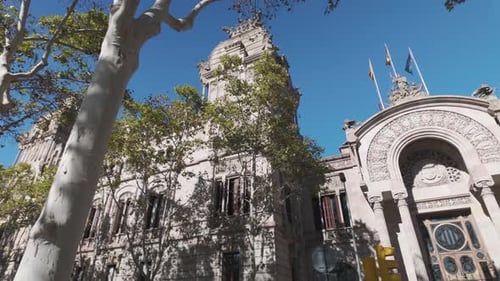 Tribunal Superior de Justicia de Cataluña mostrando banderas ondeando en un día soleado. Tiro panorámico a la derecha