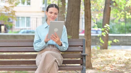 Video Chat on Tablet by Young Woman Outdoor