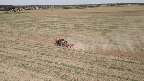 Small Tractor Cultivating Soil at Agricultural Field Aerial View