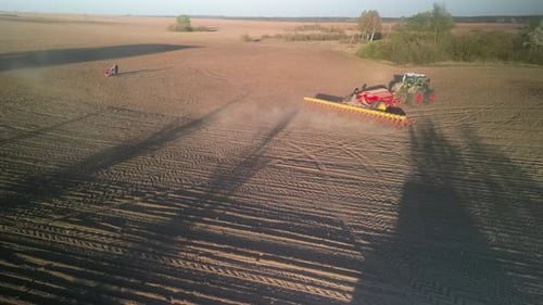 Green tractor works on the field sowing sunflower. Tractor planting corn in Ukraine