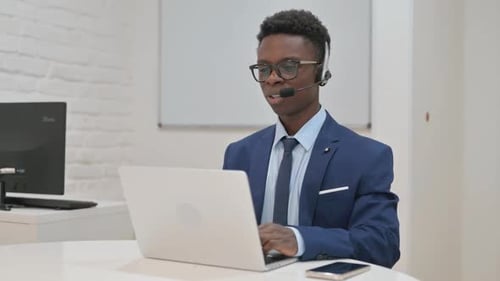Customer Service Agent with Headset on a Video Call in Call Center