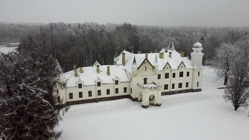 Approaching aerial drone view of Alatskivi Castle in Estonia during winter