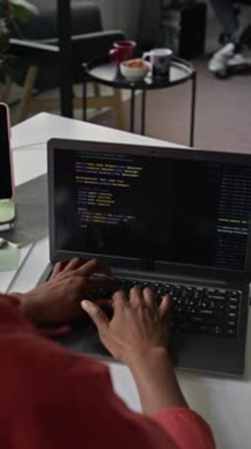Vertical of Black Female Software Engineer Coding on Laptop in Office