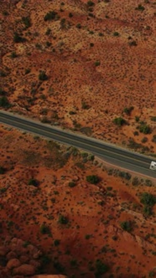 White trailer going by the road in the deserted land of Utah, USA.