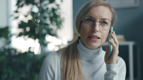Blonde Woman Talking on Mobile Phone Indoors