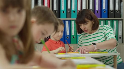 Teacher Assists Young Students with Drawing Lesson