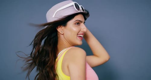 Woman, photoshoot and hat in studio, smile and light with paparazzi for model job by blue