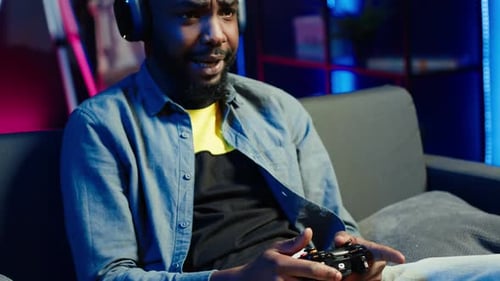 Man Playing Video Games on Couch with Controller