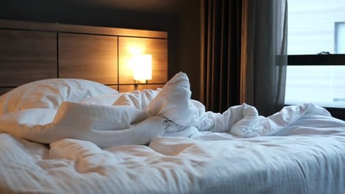 Interior of a bedroom with an unmade bed