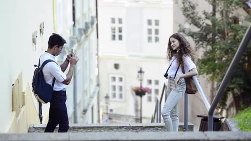 Man Takes Photo of Woman on City Steps