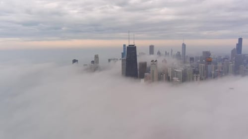 A chicago skyline consist of misty clouds. Foggy, white, beautiful, view of John Hancock tower.