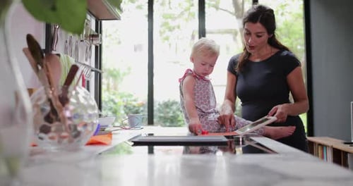 Woman and Child Using a Tablet in Kitchen