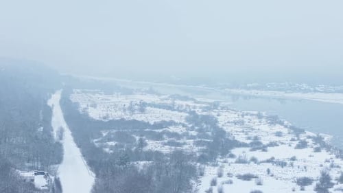 Aerial View of Snowy Winter Landscape by River