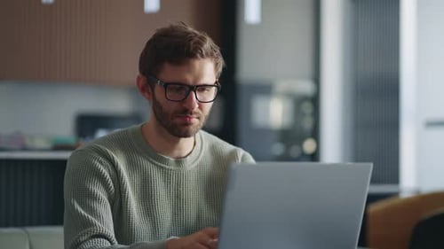 Young Adult Typing on Laptop at Home