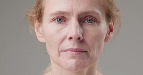 Close Up of Woman's Face Against Grey Background