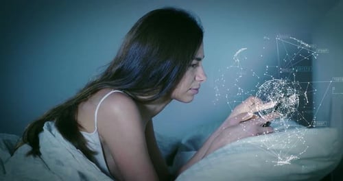 Eine Frau in ihrem Bett und benutzt ihr Telefon, um Nachrichten aus der Ferne zu senden, Videoanrufe zu tätigen und futuristisch zu wirken g