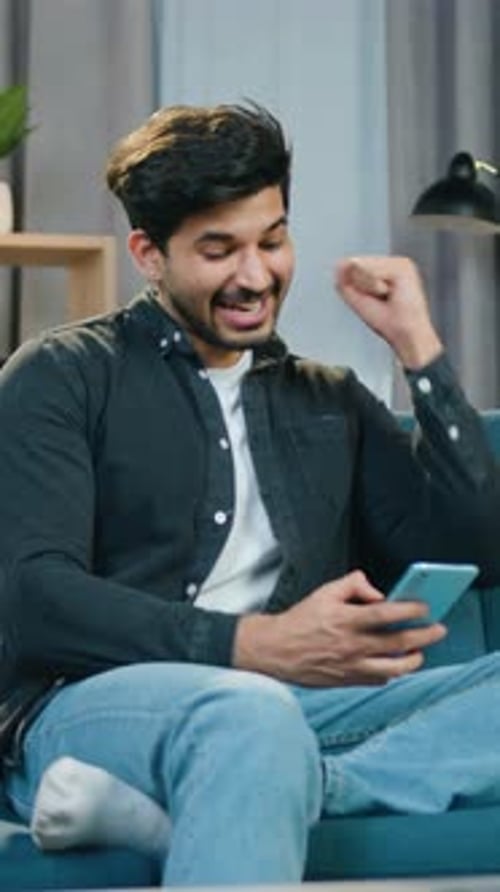 Excited Young Man Celebrates Good News on Phone