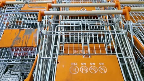 Shopping trolley lying idle at the shopping mall due to Covid. Tilt up, Close up.
